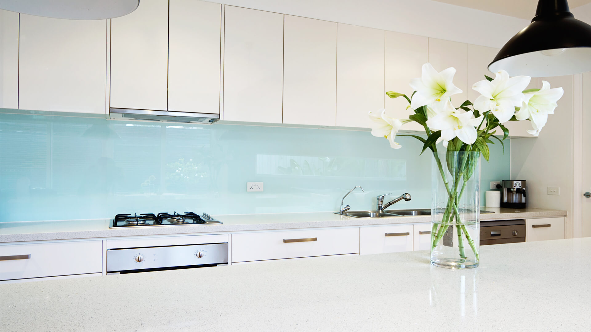 Bespoke Made Glass Kitchen portraying a blue turquoise splashback